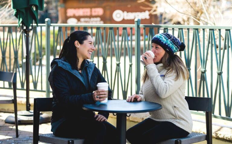 women talking and drinking outside starbucks